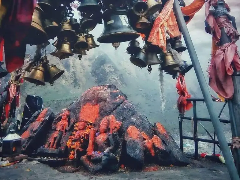 A view of Bhairavnath Temple, featuring a rocky shrine adorned with vibrant orange-red vermilion powder